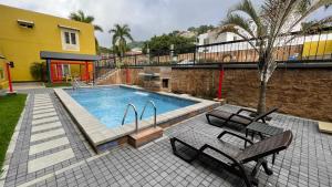 - une piscine avec 2 chaises et une table dans l'établissement Beverly Hills: Hotel and Business, à San Salvador