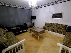 ein Wohnzimmer mit einem Sofa und einem Tisch in der Unterkunft luxe appartement Nour D'asilah 3 in Asilah
