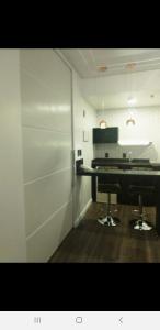 a room with a piano in a room with a kitchen at Residencial Luxo Moema - Macuco in Sao Paulo