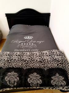a bed with a black and white comforter on it at luxe appartement Nour D'asilah 3 in Asilah