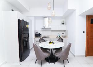 a white kitchen with a table and chairs at Apartamento S1401 en Downtown Santo Domingo in Santo Domingo