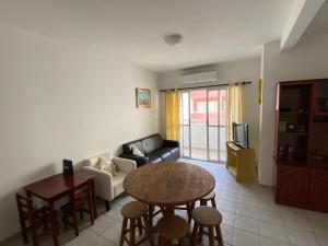 ein Wohnzimmer mit einem Tisch und einem Sofa in der Unterkunft AP COM PISCINA, CHURRASQUEIRAS, AR CONDICIONADO, até 08 adultos in Ubatuba
