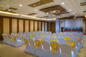 una stanza con file di sedie bianche e uno schermo di Viceroy Residency Manor a Rāmanathapuram
