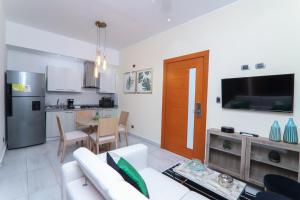 a living room with a white couch and a television at N1401 Espectacular vista Downtown Santo Domingo RD in Santo Domingo