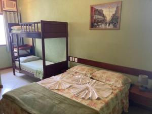 a bedroom with two bunk beds and a bed at Pousada Maravista in Anchieta