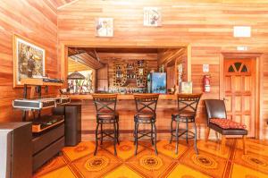 - un bar dans une pièce dotée de murs en bois et de tabourets de bar dans l'établissement Dream Valley Belize, à Teakettle Village