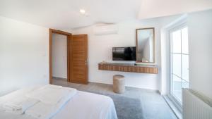 a bedroom with a bed and a tv on a wall at Midpoint Suites in Fethiye