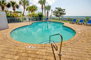 a large swimming pool with blue chairs and the ocean at Roxanne Towers 1101 in Myrtle Beach