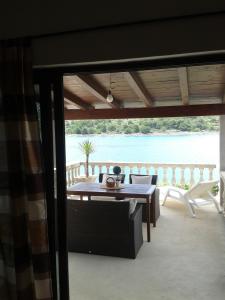 un patio con mesa y sillas y vistas al agua en Apartments Miranda, en Kaprije