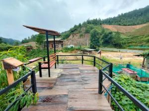 a wooden bridge over a river with a hill in the background at Mu Cang Chai Hostel in Mù Cang Chải