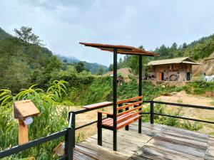 a wooden bench sitting on a wooden boardwalk with a view at Mu Cang Chai Hostel in Mù Cang Chải