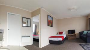 a hotel room with a bed and a television at Fiesta Court Motel in Whanganui