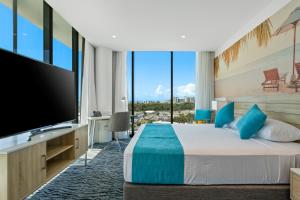 a hotel room with a bed and a large television at Rydges Gold Coast Airport in Gold Coast