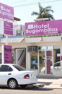 un coche blanco estacionado frente a un edificio en Hotel Bugambilias, en Ciudad Obregón