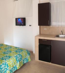 una pequeña cocina con cama y lavabo en una habitación en Hotel Bugambilias, en Ciudad Obregón