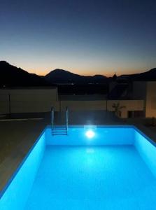 a swimming pool lit up at night with the sky at Villa Miron in Kamilari
