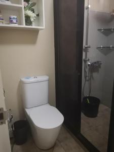 a bathroom with a white toilet and a shower at Pico de Loro Staycation (3 beds- 6 pax) in Nasugbu