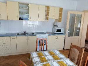 a kitchen with white cabinets and a table and a sink at Casă de oaspeți ORSO in Sovata +16 photos