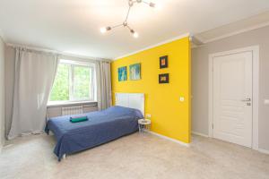 a bedroom with a bed and a yellow wall at City Jazz studio in Kaliningrad