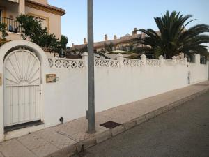 een wit hek met een deur aan de straatkant bij Saint James Park upstairs in Orihuela-Costa