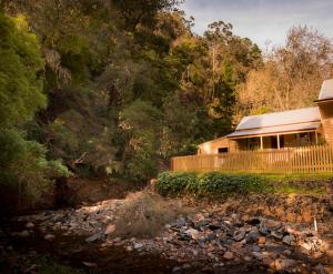 a house on a hill next to a river at Creek Cottage in Walhalla