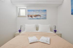 um quarto com uma cama com duas almofadas brancas em Rhea Silvia em Dubrovnik