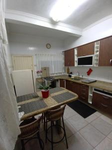 een keuken met een tafel en stoelen en een koelkast bij Casa 100mtrs do mar com piscina aquecida in Praia Grande