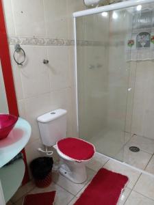 een badkamer met een douche en een toilet met een rode stoel bij Casa 100mtrs do mar com piscina aquecida in Praia Grande