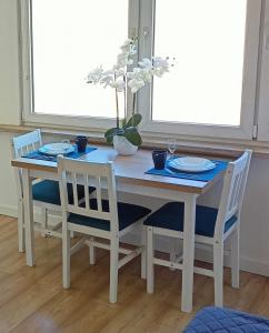 tavolo da pranzo con due sedie e un tavolo con piatti di Apartament Toruń Dreams a Toruń