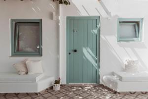 a green door in a white room with stairs at Lilika's Luxury Maisonette by Estia in Hersonissos