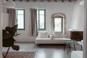 a white living room with a white couch and windows at Lilika's Luxury Maisonette by Estia in Hersonissos
