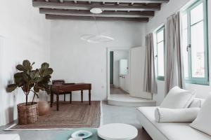 a living room with a white couch and a piano at Lilika's Luxury Maisonette by Estia in Hersonissos