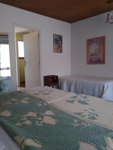 sypialnia z 2 łóżkami i zielonym kocem w obiekcie Hotel Le Mas Fleuri w mieście Vernet-les-Bains