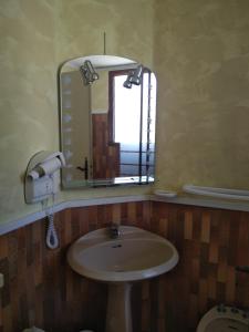 a bathroom with a sink and a mirror at Hotel Le Mas Fleuri in Vernet-les-Bains