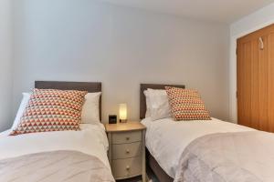 1 dormitorio con 2 camas y mesita de noche con lámpara en Finest Retreats - Belle House, Apt 6, en Filey