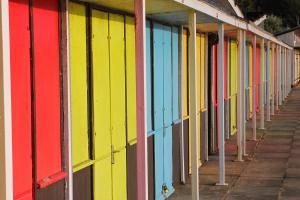 una fila de edificios de colores brillantes en una acera en Finest Retreats - Belle House, Apt 6, en Filey