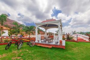 un gazebo con biciclette parcheggiate sull'erba di La Palm by StayVista - Mountain-view villa, boasting a spacious pool, Gym, Indoor games, Basketball court & A lush lawn with a gazebo a Lonavala