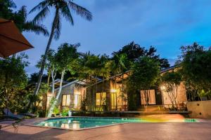 a villa with a swimming pool in front of a house at Family House @ Pai in Pai