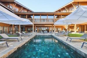 a swimming pool with chairs and umbrellas in a building at Pirin Golf Hotel Private Studios - Sani, Bansko in Razlog