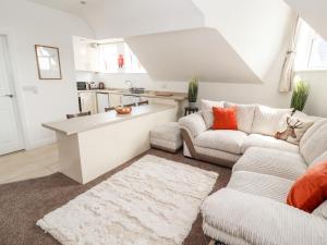 a living room with two couches and a kitchen at Flat 3 in Prestatyn