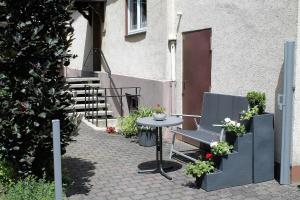 a patio with a table and a chair in front of a building at Ferienwohnung Ortsmitte in Hilders
