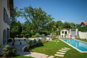 a backyard with a swimming pool and a house at Hôtel Villa la Renaissance in Bayonne