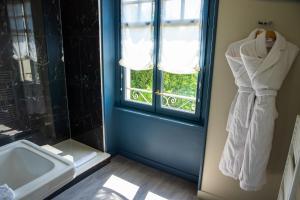 a bathroom with a sink and a window with towels at Hôtel Villa la Renaissance in Bayonne