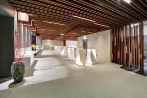 una hall con tavoli bianchi e un vaso di The Act Hotel Sharjah a Sharjah