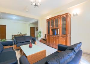 a living room with couches and a wooden entertainment center at BedChambers Serviced Apartments - Artemis Hospital in Gurgaon