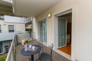 a balcony with a table and chairs and a vase of flowers at Torbole Relax, Pool & Balcony Apartment in Nago-Torbole +59 photos