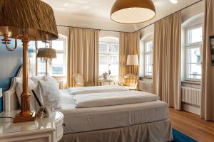 a bedroom with a large bed and a table with a lamp at Hotel & Restaurant Posthalterei in Zusmarshausen +43 photos