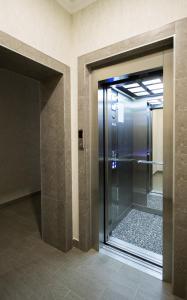 un ascenseur en verre dans un bâtiment avec une porte en verre dans l'établissement D Hotel, à Krasnodar