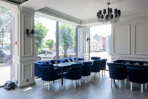 a dining room with blue chairs and a table at Grand Royal in Chernivtsi