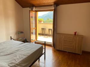 1 dormitorio con 1 cama y puerta corredera de cristal en Casa Elvy Al Lago en Cannobio